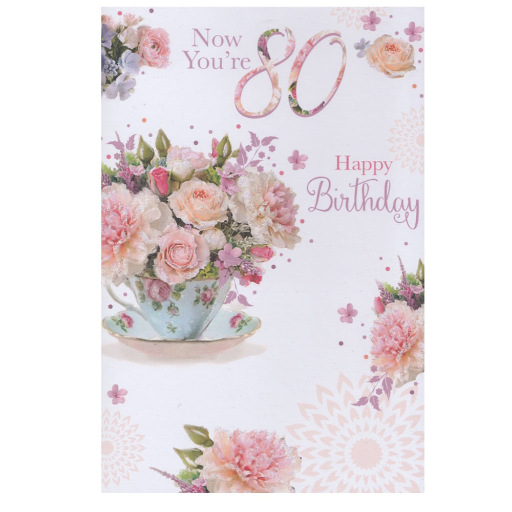 Front of this 80th birthday card features an illustration of a flower filled teacup, paired with a message.