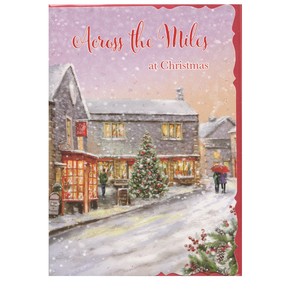 Front of this card features an illustration of a couple walking down a snowy country village lane, lit up by Christmas lights, paired with a message.