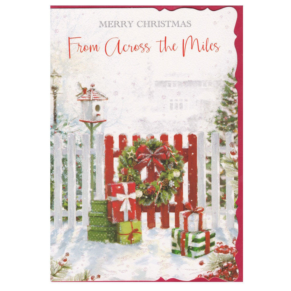 Front of this card features an illustration of a snowy scene with a red garden gate decorated with a Christmas wreath, paired with a message.