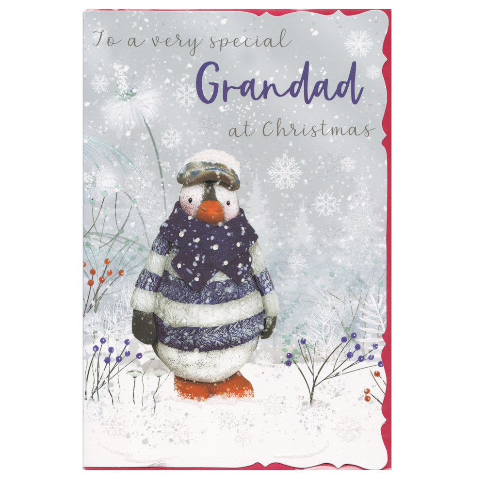 Front of this grandad Christmas card features an illustration of a penguin wearing a striped jumper in a snowy scene, paired with a message.