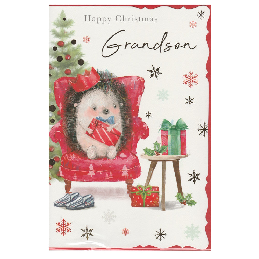 Front of this grandson Christmas card features an illustration of an hedgehog sat in a armchair with a Christmas tree and presents, paired with a message.