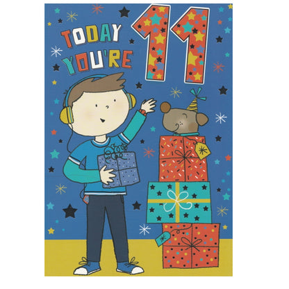 Front of this 11th birthday card features an illustration of boy standing near a stack of presents, paired with a message.