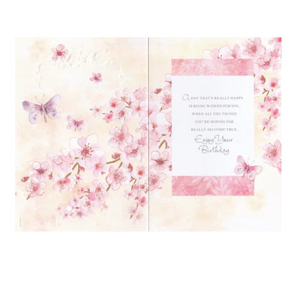Front of this 60th birthday card features an illustration of a butterflies and pink flowers, paired with a message.