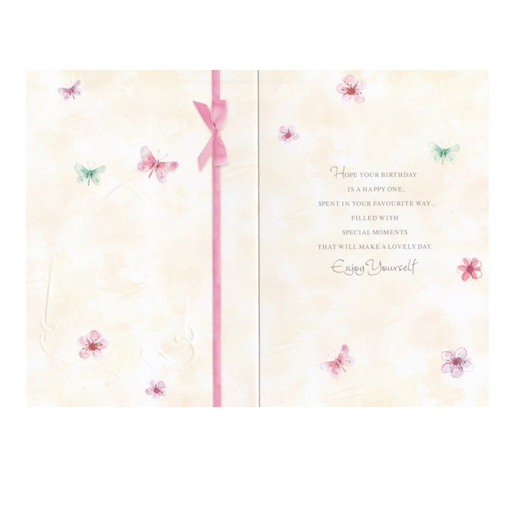 Front of this 65th birthday card features an illustration of a envelope filled with flowers, paired with a message.