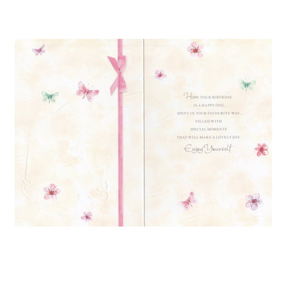 Front of this 65th birthday card features an illustration of a envelope filled with flowers, paired with a message.