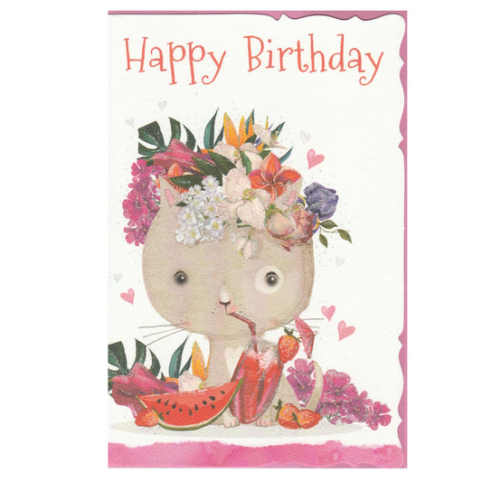 Front of this birthday card features an illustration of a cartoon cat wearing a floral crown and surrounded by fruits and flowers, paired with a message.
