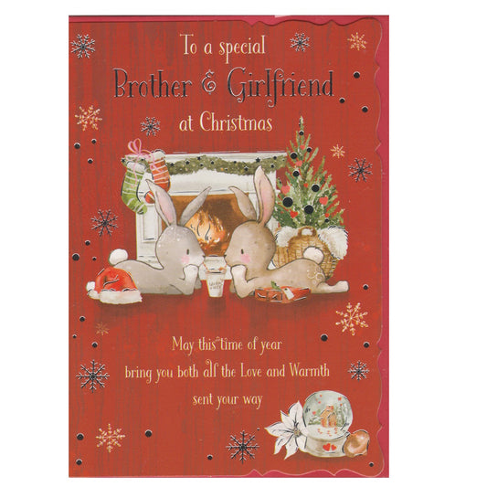Front of this brother and girlfriend Christmas card features an illustration of two bunny rabbits lying down in front of a lit fireplace, decorated for Christmas, paired with a message.