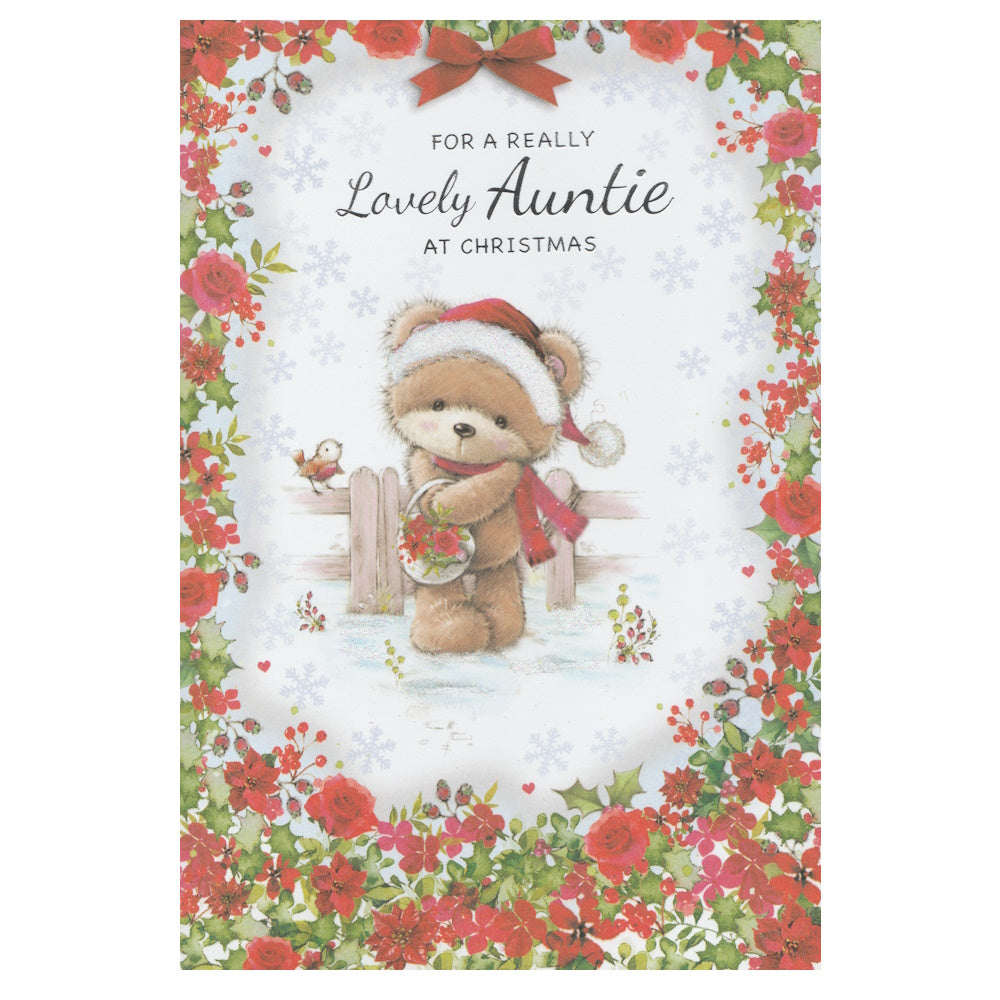 Front of this auntie christmas card features an illustration of a teddy bear wearing a Santa hat, holding a basket of poinsettias, surrounded by a floral border of red and green flowers, paired with a message.