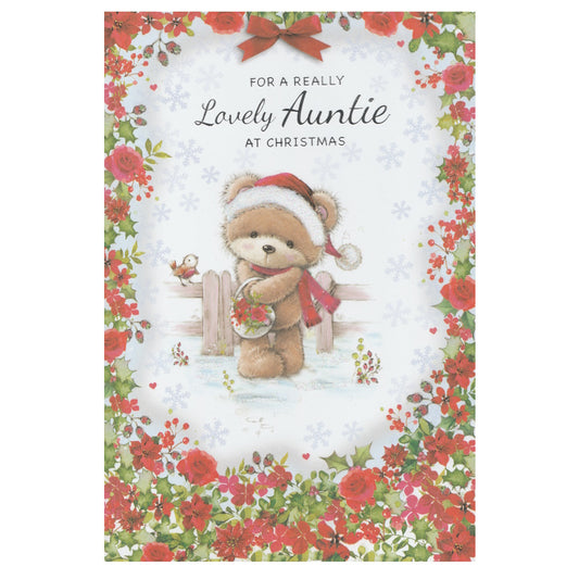 Front of this auntie christmas card features an illustration of a teddy bear wearing a Santa hat, holding a basket of poinsettias, surrounded by a floral border of red and green flowers, paired with a message.