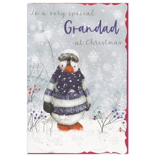 Front of this grandad Christmas card features an illustration of a penguin wearing a striped jumper in a snowy scene, paired with a message.
