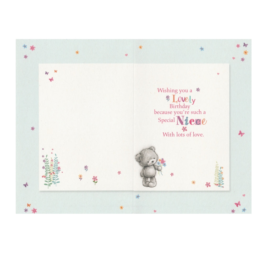 Front of this niece birthday card features an illustration of a bear with flowers, paired with a message.